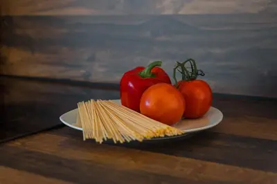 a plate with tomatoes and pasta on a table at Pia´s Bleibe in Caldaro