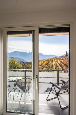 a glass door leading to a patio with a table and chairs at Pia´s Bleibe in Caldaro