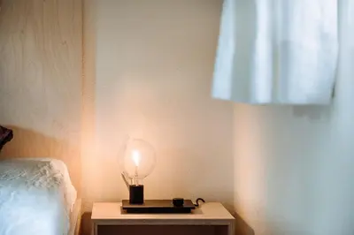 a lamp on a table next to a bed at Mountain house Ebner in Selva dei Molini