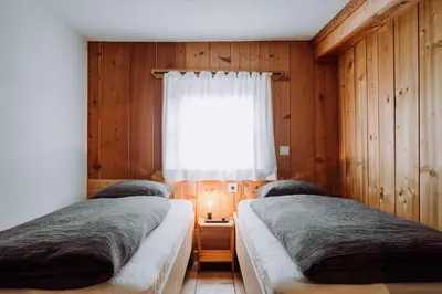 two beds in a room with a window at Mountain house Ebner in Selva dei Molini