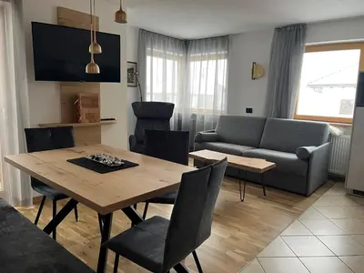 a living room with a table and a couch at A Sosta in Selva di Val Gardena