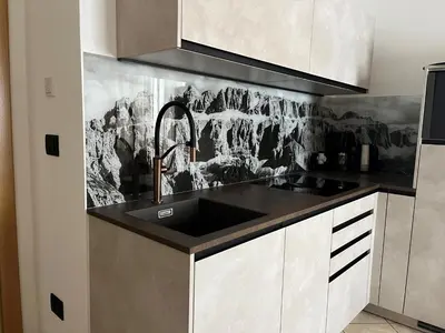 a kitchen with a sink and a black counter top at A Sosta in Selva di Val Gardena
