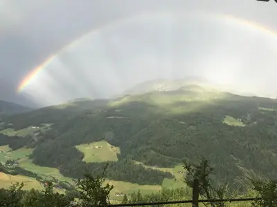a rainbow in the sky over a mountain at Oeberst-hof in Sarntal