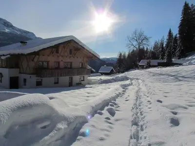 a snow covered house with footprints in front of it at Oeberst-hof in Sarntal
