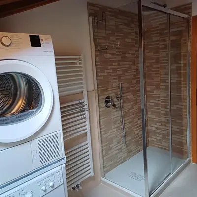 a washing machine and a washer in a bathroom at Casa Luisa in Tesero