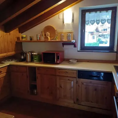 a kitchen with a counter with a microwave and a window at Casa Luisa in Tesero