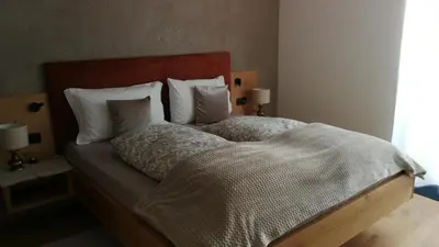 a bedroom with a large bed with white sheets and pillows at BioTop Appartement Kronplatz in Perca