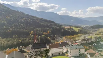 a small town in the mountains with houses and trees at BioTop Appartement Kronplatz in Perca