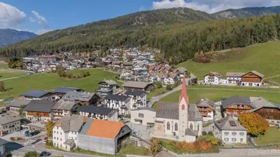 an aerial view of a small town with a church at BioTop Appartement Kronplatz in Perca