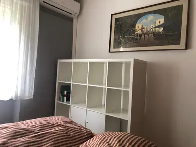 a bedroom with a bed and a white book shelf at Guesthouse Gigli 2 - Free Tourist Card & car parking - no trucks in Bolzano