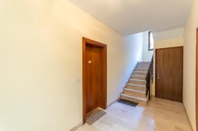 a hallway with a wooden door and stairs at Appartamento Alessia in Rocca Pietore