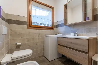 a bathroom with a toilet and a sink and a mirror at Appartamento Alessia in Rocca Pietore