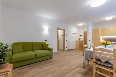 a living room with a green couch and a table at Appartamento Alessia in Rocca Pietore