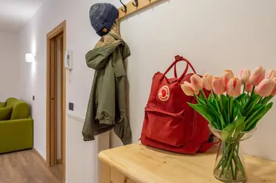 a vase of pink tulips and a red bag on a table at Appartamento Alessia in Rocca Pietore