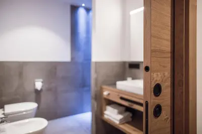 a bathroom with a sink and a toilet at ROUDA luxury retreat am Kronplatz in Valdaora