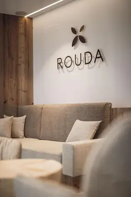 a living room with a couch and a sign on the wall at ROUDA luxury retreat am Kronplatz in Valdaora