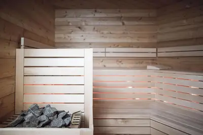 a sauna with wood paneled walls at ROUDA luxury retreat am Kronplatz in Valdaora