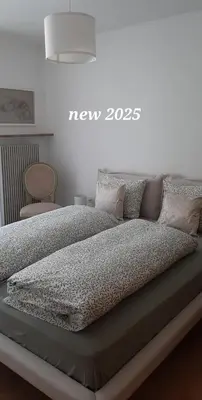 a bed with a new sign on the wall at LAnJA ihr besonderes Urlaubszuhause in Lagundo