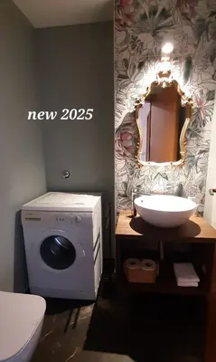 a bathroom with a washing machine and a mirror at LAnJA ihr besonderes Urlaubszuhause in Lagundo