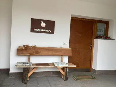 a wooden bench sitting in front of a door at Bbmarlene in Bolzano