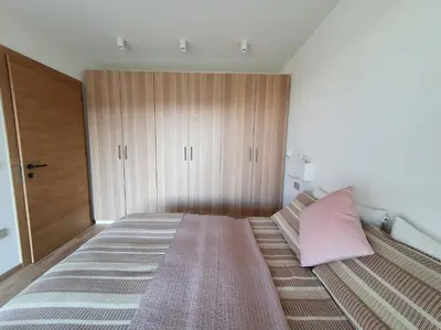 a bedroom with a large bed with a pink pillow at Casa Grutzen Design Apartment with Pool in Bolzano in Bolzano