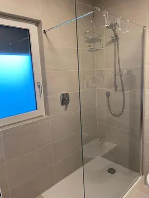a shower with a glass door in a bathroom at Casa Grutzen Design Apartment with Pool in Bolzano in Bolzano