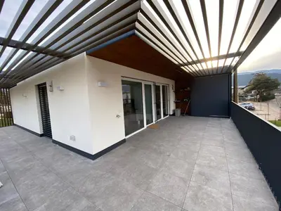a large patio with a wooden ceiling at Casa Grutzen Design Apartment with Pool in Bolzano in Bolzano