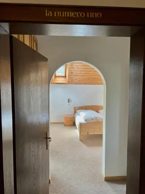 a bedroom with a bed and an open door at Ameiserhof Guesthouse in Collalbo
