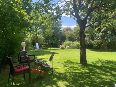 a statue of a man sitting on a chair in a park at Ameiserhof Guesthouse in Collalbo