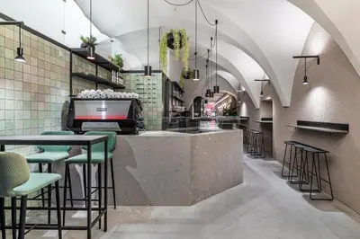 a restaurant with a bar with green stools at Stay COOPER l CITY LOFT in Bolzano