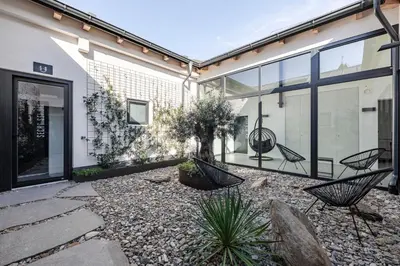 a courtyard with chairs and plants in a house at Stay COOPER l CITY LOFT in Bolzano