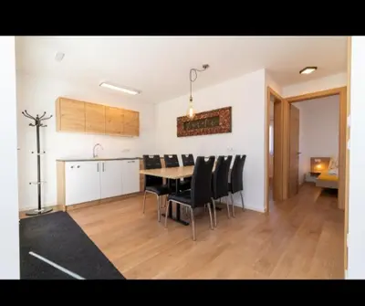 a dining room and kitchen with a table and chairs at SUNNLEITN HOF in Nova Ponente