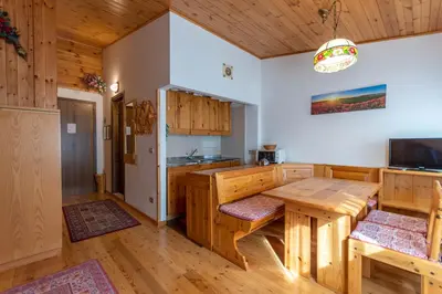 a kitchen with wooden cabinets and a wooden table at Petit Arnica in Selva di Cadore