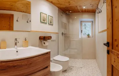 a bathroom with a tub and a toilet and a sink at Luxury Chalet Liosa - Ski in Ski out - Amazing view in Corvara in Badia