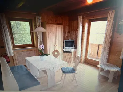 a living room with a table and chairs and a tv at Appartaments Sanderhof in La Valle