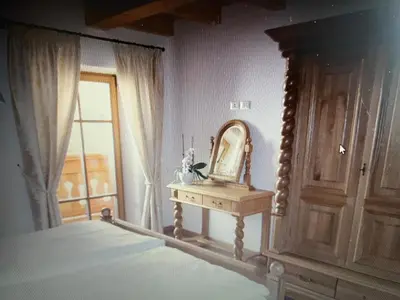 a bedroom with a bed and a mirror on a table at Appartaments Sanderhof in La Valle