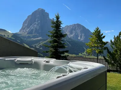 a hot tub with a view of a mountain at Apartments La Baita in Santa Cristina in Val Gardena
