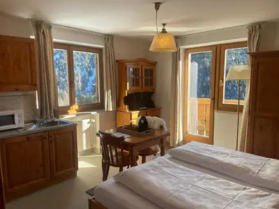a bedroom with a bed and a desk and a table at PLOSE Parkhotel & Residence in Bressanone