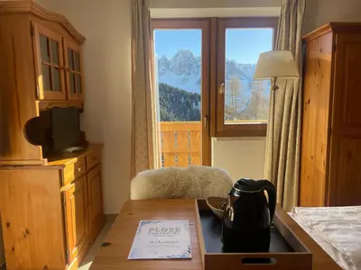 a hotel room with a table and a large window at PLOSE Parkhotel & Residence in Bressanone