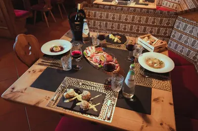 a wooden table with plates of food on it at PLOSE Parkhotel & Residence in Bressanone