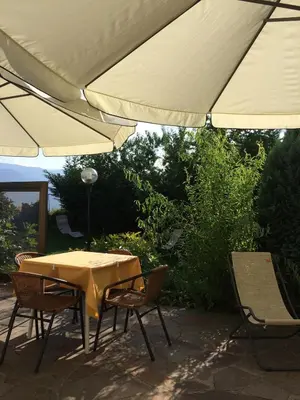 a table and chairs under an umbrella on a patio at Pension an der Mayenburg in Vollan