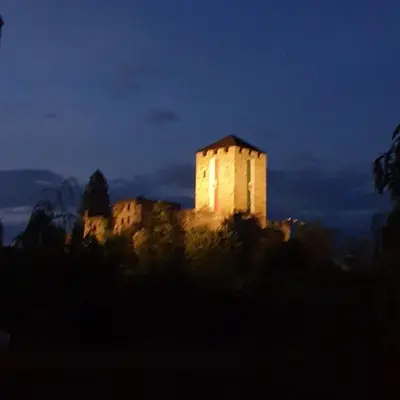 a building on top of a hill at night at Pension an der Mayenburg in Vollan