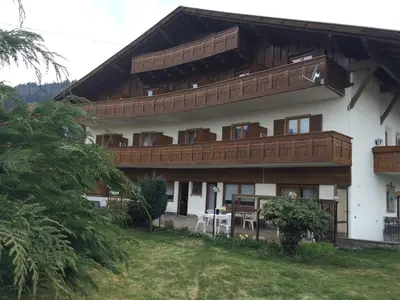 a large white building with wooden balconies on it at Pension an der Mayenburg in Vollan