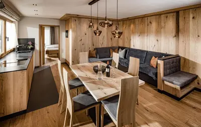 a dining room with a table and a couch at Apartments Belaval in Santa Cristina in Val Gardena