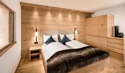 a bedroom with a large bed with a furry blanket at Apartments Belaval in Santa Cristina in Val Gardena