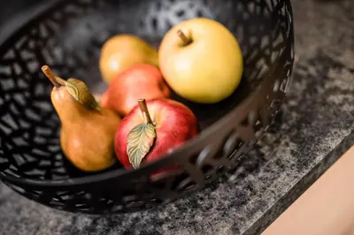 a basket filled with apples and pears on a counter at Apartments Belaval in Santa Cristina in Val Gardena