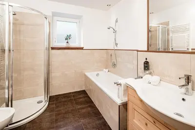a bathroom with a tub and a sink and a shower at Apartment Bellaria in Santa Cristina in Val Gardena