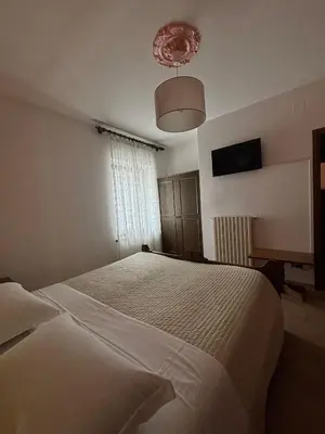 a bedroom with a white bed and a window at Hotel Miravalle in Imer