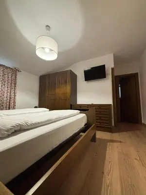 a bedroom with a bed and a flat screen tv at Hotel Miravalle in Imer