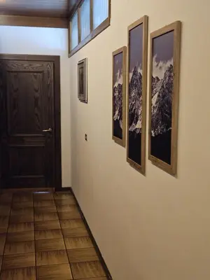 a hallway with a door and four pictures on the wall at Hotel Miravalle in Imer